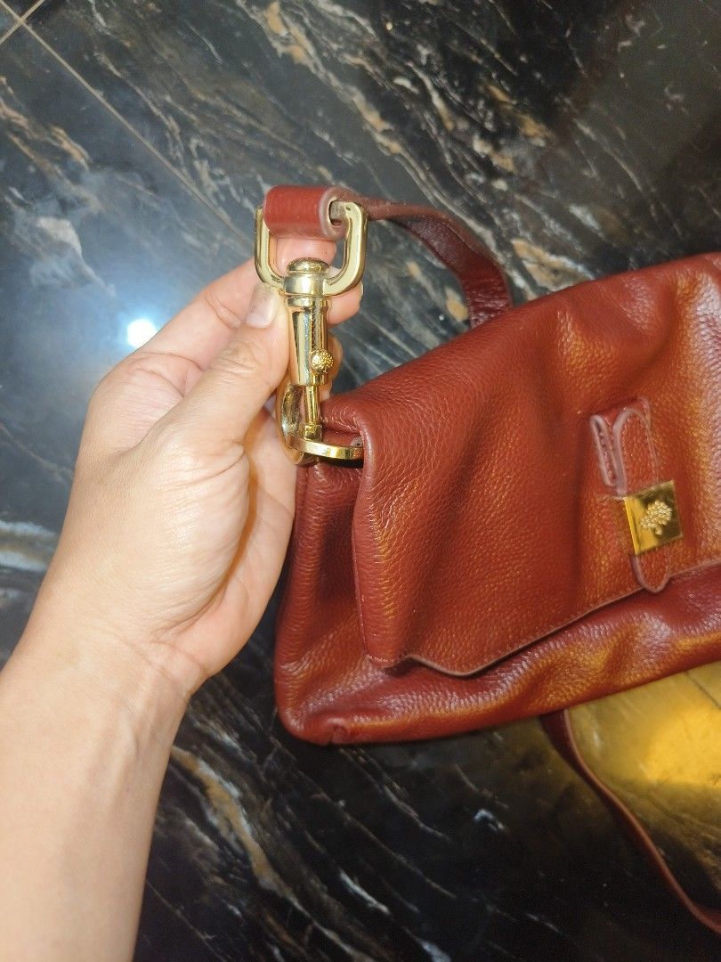 Mulberry Red Leather Shoulder Bag (Category: Luxury Bags & Wallets) located in Davao. Submitted by myrvelynjo32302 (Listing ID 1459825078, Image 2). Description: - Authentic Mulberry shoulder bag - Luxurious deep red pebbled leather - Elegant gold hardware details - Versatile: top handle and longer strap for shoulder/crossbody wear - Spacious interior with a zip pocket - Signature Mulberry tree logo lining - "Made in England" tag visible inside -