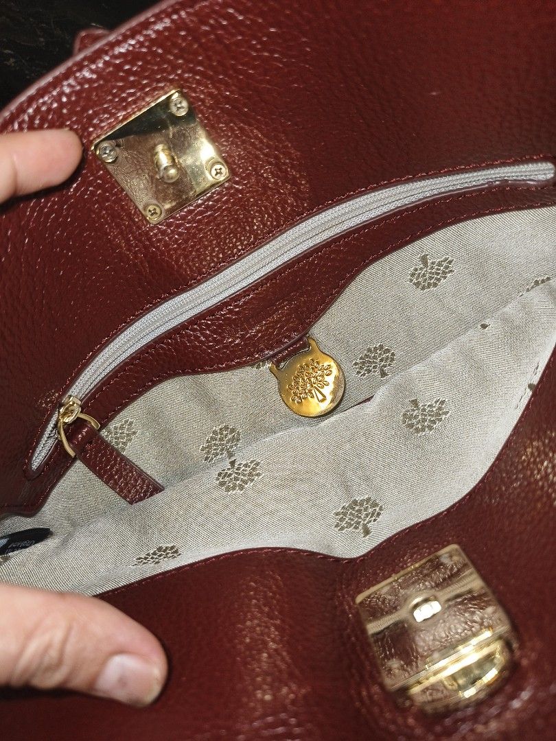Mulberry Red Leather Shoulder Bag (Category: Luxury Bags & Wallets) located in Davao. Submitted by myrvelynjo32302 (Listing ID 1459825078, Image 3). Description: - Authentic Mulberry shoulder bag - Luxurious deep red pebbled leather - Elegant gold hardware details - Versatile: top handle and longer strap for shoulder/crossbody wear - Spacious interior with a zip pocket - Signature Mulberry tree logo lining - "Made in England" tag visible inside -