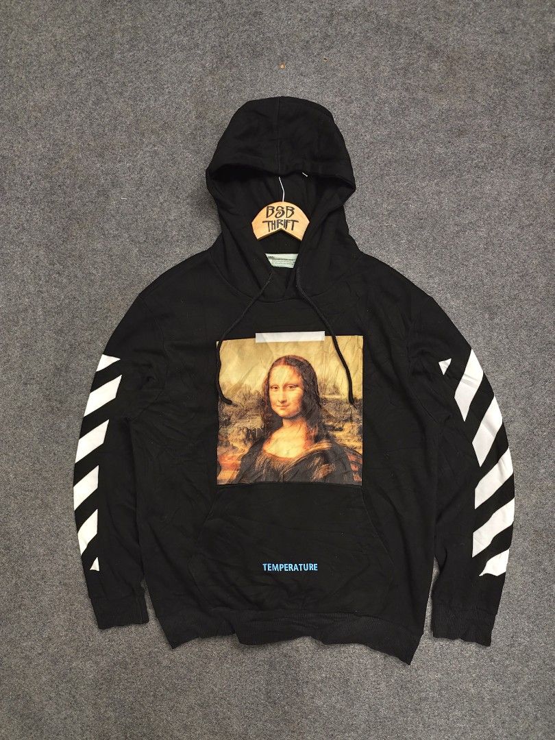 OFF-WHITE Mona Lisa Hoodie Black (Category: Coats, Jackets and Outerwear) located in Cordova. Submitted by bsb.streetluxvintage.clothing (Listing ID 1459795041, Image 1). Description: - Authentic OFF-WHITE Hoodie - Color: Black - Size: 2 - Iconic Mona Lisa graphic on front - Signature OFF-WHITE diagonal stripes on sleeves - 'TEMPERATURE' text detail on front pocket and back - Made in Italy.