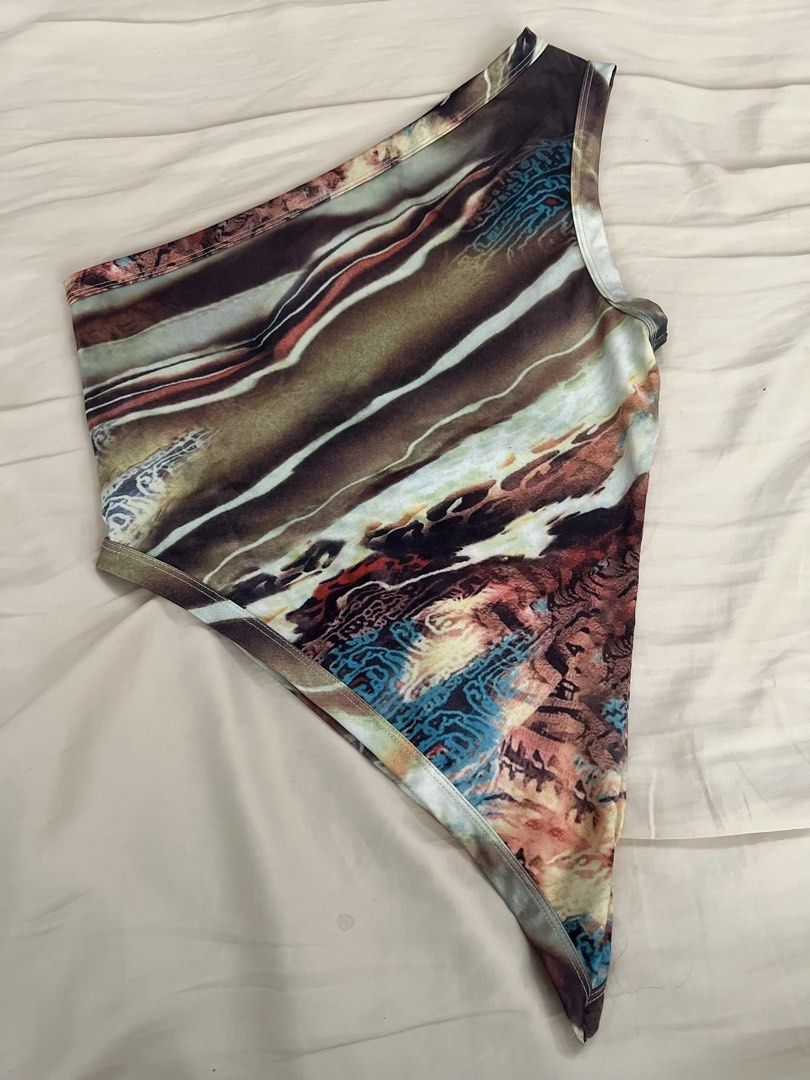 One Shoulder Abstract Print Asymmetrical Top (Category: Sleeveless) located in Pasig City. Submitted by crybaby666 (Listing ID 1459752439, Image 1). Description: - Stylish one-shoulder design - Eye-catching abstract print featuring brown, beige, blue, and red accents - Flattering asymmetrical hemline for a unique look - Comfortable stretchy material - Versatile: Great for casual days or a night out.