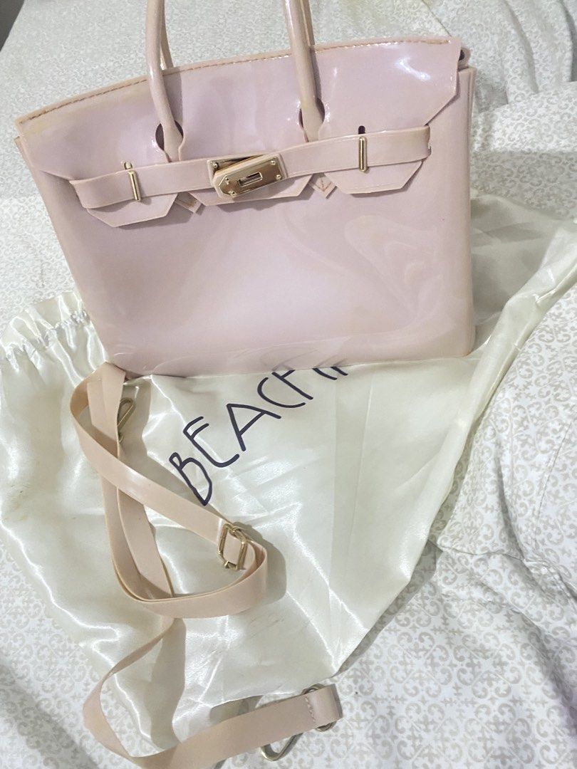 Pale Pink Jelly Handbag with Shoulder Strap (Category: Shoulder Bags) located in Quezon City. Submitted by irldn_ (Listing ID 1459807172, Image 1). Description: - Needs a little cleaning - Issue: No lock - Pale pink jelly handbag - Features a gold lock closure - Comes with a detachable shoulder strap - Shiny, eye-catching finish - Includes a 'BEACH' dust bag - Versatile for everyday use or evening events.