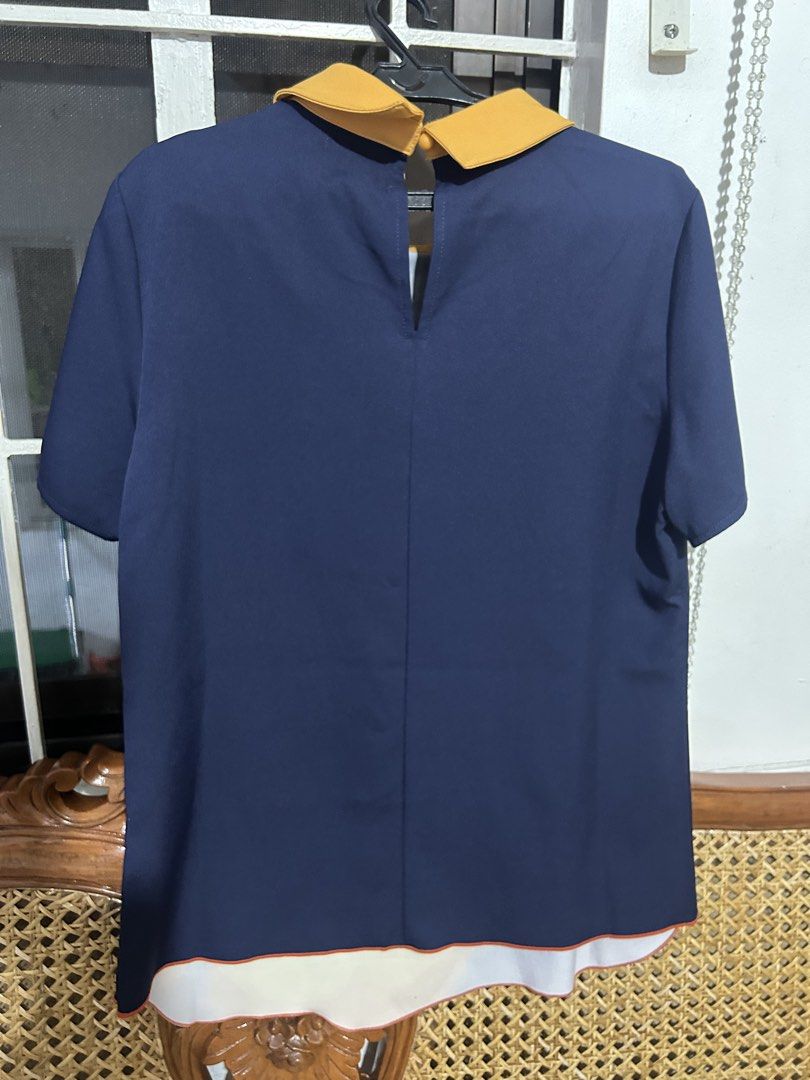 Plains & Prints Navy Blue Floral Collared Top Size M (Category: Blouses) located in Santa Rosa. Submitted by vastmountain.c924cd (Listing ID 1459792977, Image 2). Description: Once lang nagamit - Navy blue top from Plains & Prints - Size M - Yellow Peter Pan collar - Large yellow and orange rose print with red vine details on the front - Short sleeves with button details - Plain navy blue back - White and orange trim on the hem.