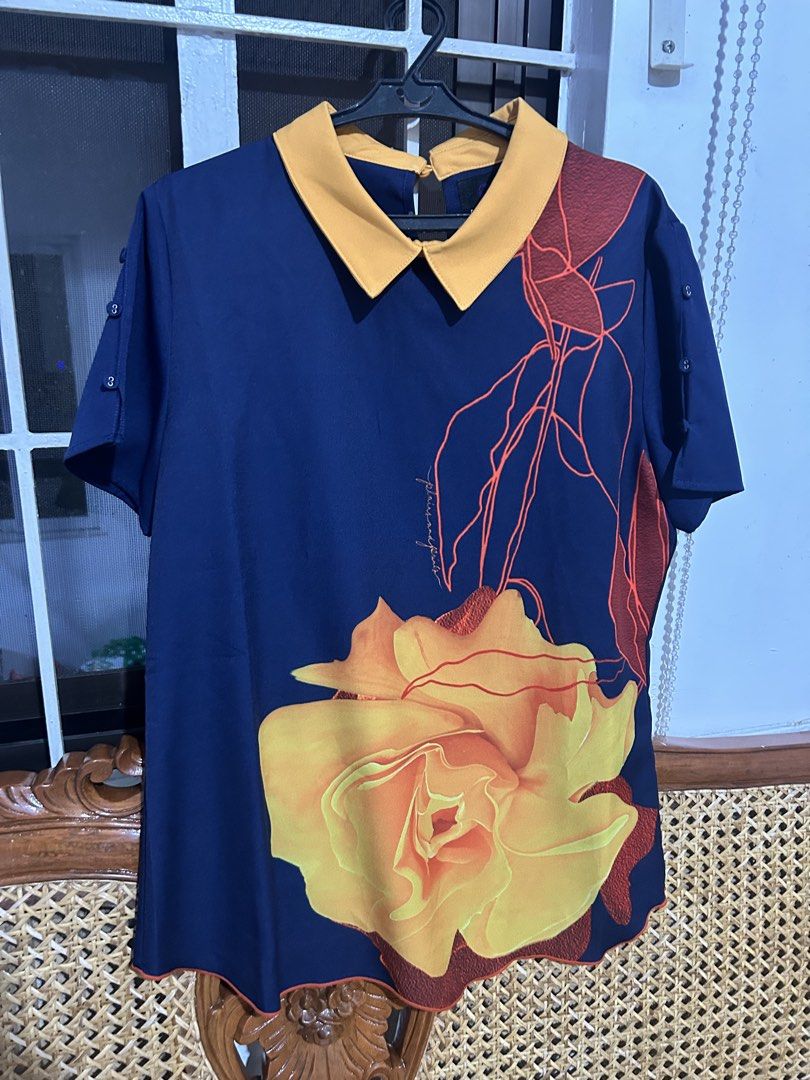 Plains & Prints Navy Blue Floral Collared Top Size M (Category: Blouses) located in Santa Rosa. Submitted by vastmountain.c924cd (Listing ID 1459792977, Image 1). Description: Once lang nagamit - Navy blue top from Plains & Prints - Size M - Yellow Peter Pan collar - Large yellow and orange rose print with red vine details on the front - Short sleeves with button details - Plain navy blue back - White and orange trim on the hem.