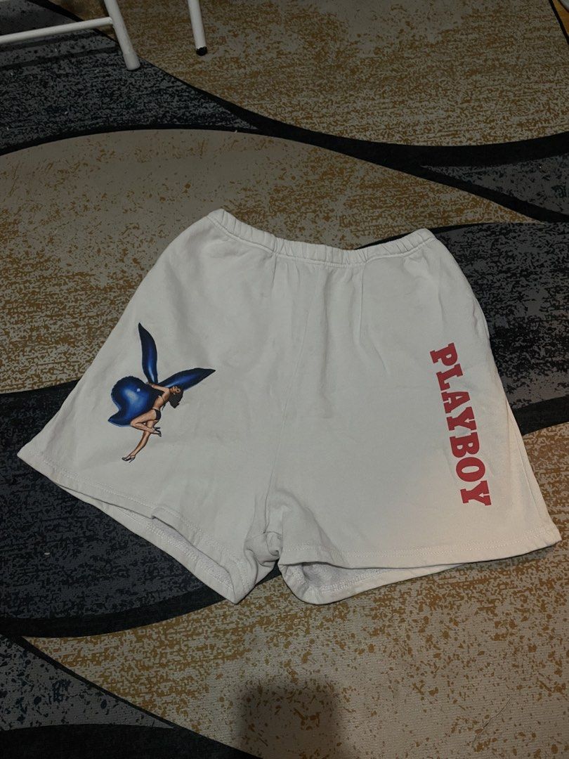 Playboy White Shorts with Graphic Print - Size M (Category: Shorts) located in Lapu Lapu. Submitted by ruby_welly22 (Listing ID 1459803577, Image 1). Description: - Features the classic Playboy bunny logo graphic on the left leg. - Playboy text printed vertically on the right leg. - Elastic waistband for a comfortable fit. - Made from a soft cotton-polyester blend. - Ideal for everyday casual wear..