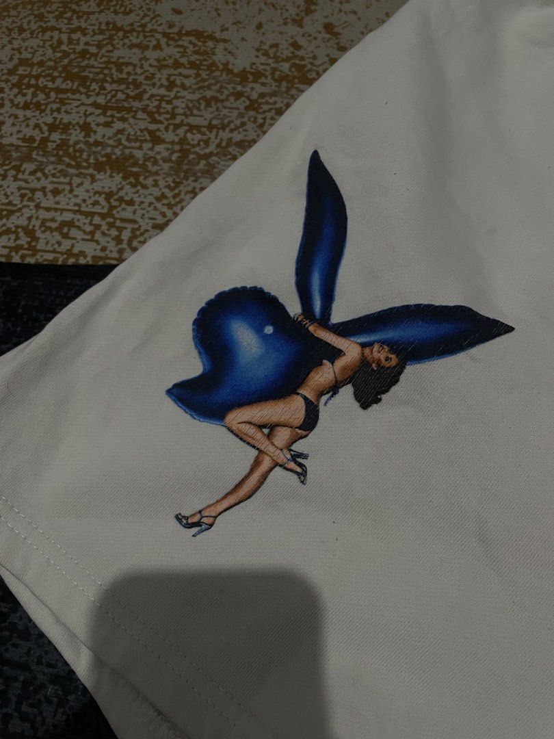Playboy White Shorts with Graphic Print - Size M (Category: Shorts) located in Lapu Lapu. Submitted by ruby_welly22 (Listing ID 1459803577, Image 3). Description: - Features the classic Playboy bunny logo graphic on the left leg. - Playboy text printed vertically on the right leg. - Elastic waistband for a comfortable fit. - Made from a soft cotton-polyester blend. - Ideal for everyday casual wear..