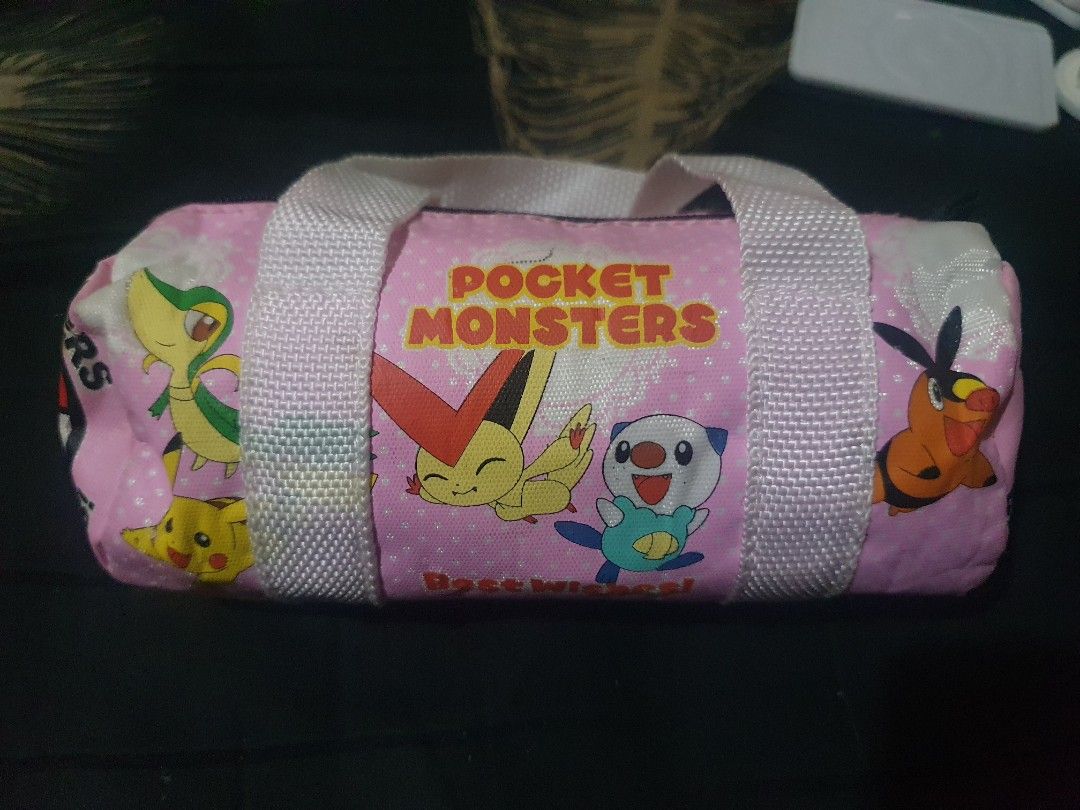 Pokemon "Pocket Monsters" mini Duffle Pouch Bag (Category: Purses & Pouches) located in Quezon City. Submitted by collectionneursonline88 (Listing ID 1459809843, Image 1). Description: - Adorable pink pouch featuring popular Pokemon characters: Pikachu, Snivy, Oshawott, Torchic, and Victini. - "Pocket Monsters" and "Best Wishes" text adds a nostalgic touch. - Features a secure zipper closure and two convenient handles. - Ideal for organizing and 