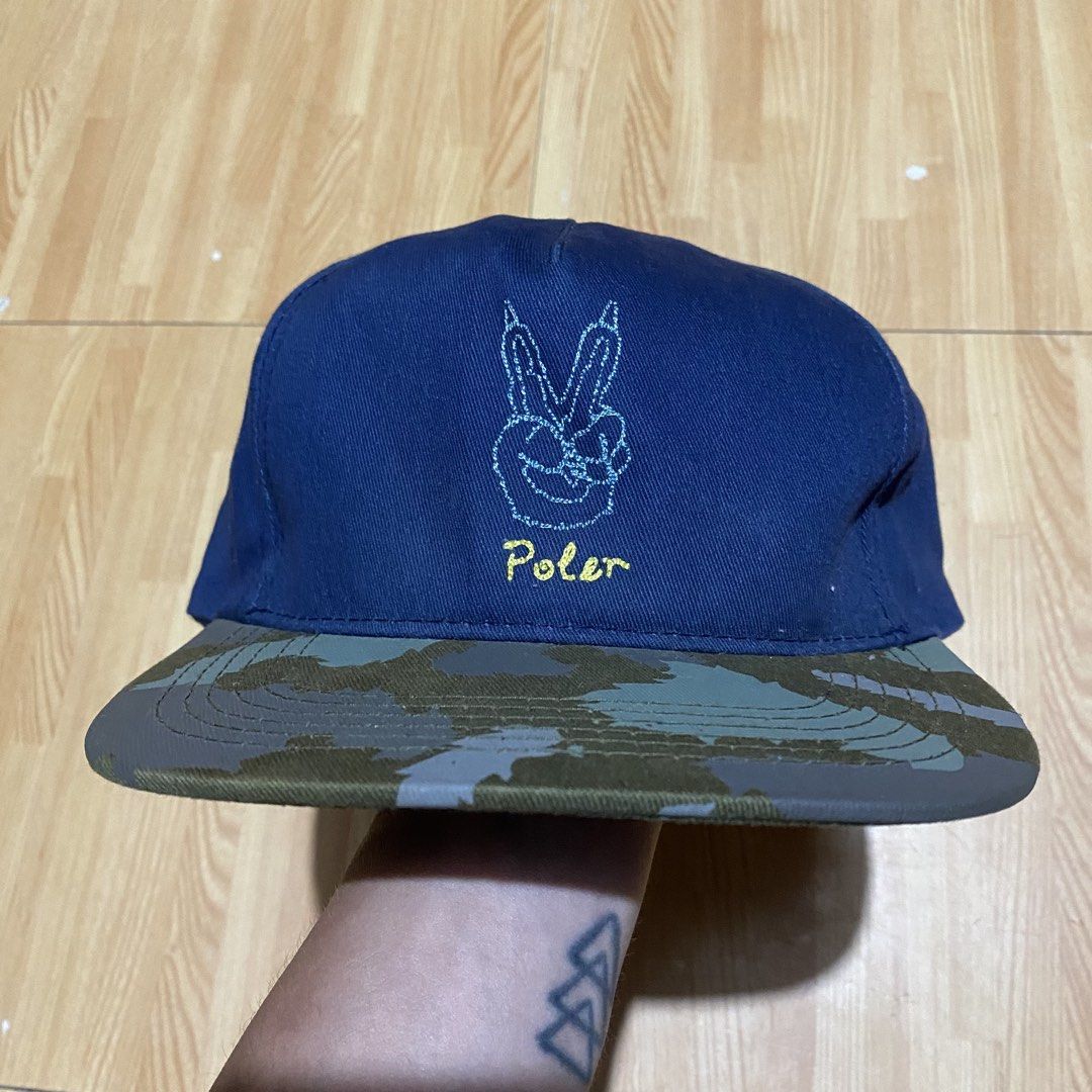 Poler Peace Snapback (Category: Caps & Hats) located in Manila. Submitted by killthismane (Listing ID 1459819358, Image 3). Description: Poler Peace Paw snapback cap featuring a blue crown with an embroidered peace-sign paw graphic and a contrasting camouflage flat brim. .