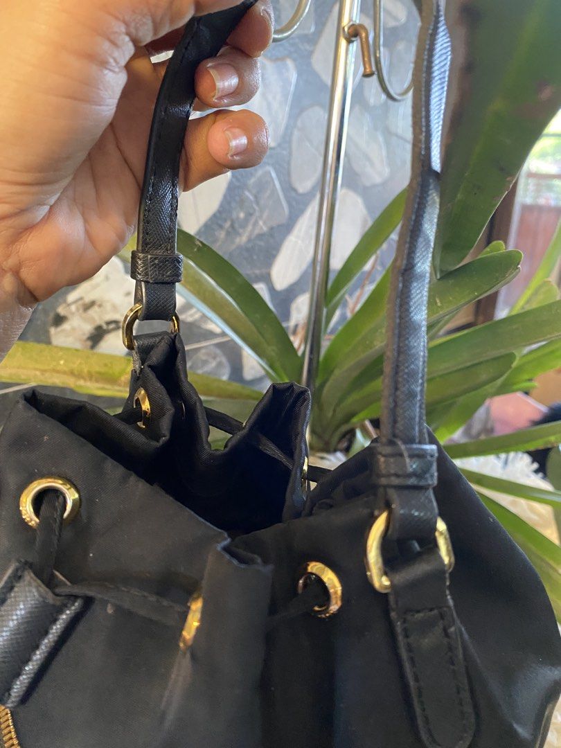 Prada Black Nylon Drawstring Bucket Bag (Category: Luxury Bags & Wallets) located in Bacolod City. Submitted by chuchaystuffs (Listing ID 1459718462, Image 3). Description: - Authentic Prada Bucket Bag - Color: Black - Material: Nylon with Gold Hardware - Closure: Drawstring - Features: Front zip pocket, leather trim and base, adjustable straps - Condition: Clean inside and out - Ideal for: Everyday use.