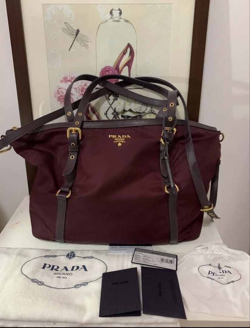 Prada Tessuto Saffiano Burgundy (Category: Luxury Bags & Wallets) located in San Antonio. Submitted by hANNdpicked (Listing ID 1459694114, Image 3). Description: - Authentic Prada tote bag - Color: Burgundy - Material: Nylon with grained leather trim - Hardware: Gold details - Includes: Dust bag and authenticity cards - Features: Spacious interior - Versatile: Can be worn as a shoulder bag or tote -Like new.