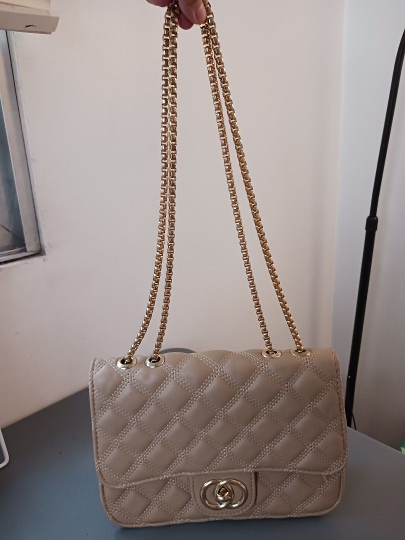 Quilted Chain Shoulder Bag with CC Logo Clasp (Category: Luxury Bags & Wallets) located in Quezon City. Submitted by rdonelle (Listing ID 1459774243, Image 1). Description: - Beige quilted shoulder bag - Elegant gold chain strap - Classic CC-style clasp closure - Interior zippered pocket for essentials - Versatile for nights out or everyday wear - Clean interior.