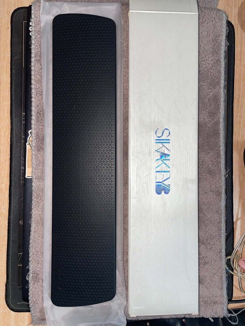 SIKAKEB Wrist Rest for Mechanical Keyboard (Category: Computer Keyboard) located in Pasay City. Submitted by nagumeow (Listing ID 1459860256, Image 2). Description: - SIKAKEYB wrist rest - Black textured surface - Honeycomb pattern on the side - Includes original box - Enhances comfort during long typing sessions.