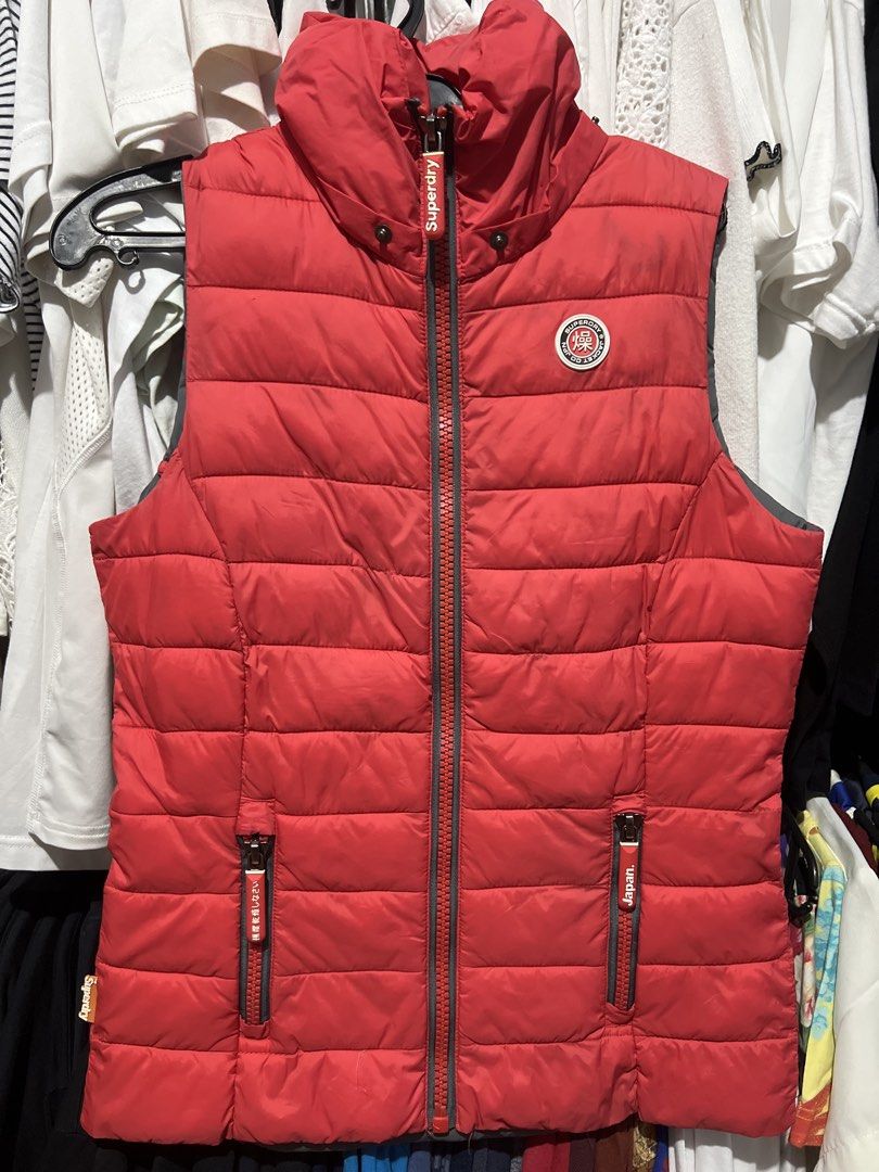 Superdry Red Puffer Vest Jacket (Category: Coats, Jackets and Outerwear) located in Rizal. Submitted by 411tatedgirl (Listing ID 1459792791, Image 1). Description: - Red Superdry puffer vest - Size XS - Classic Superdry logo patch on chest - Front zip pockets with Japanese text detail - Inner lining features Superdry Japan logo and mountain graphic - Missing Hood - Used once tapos naitago na.