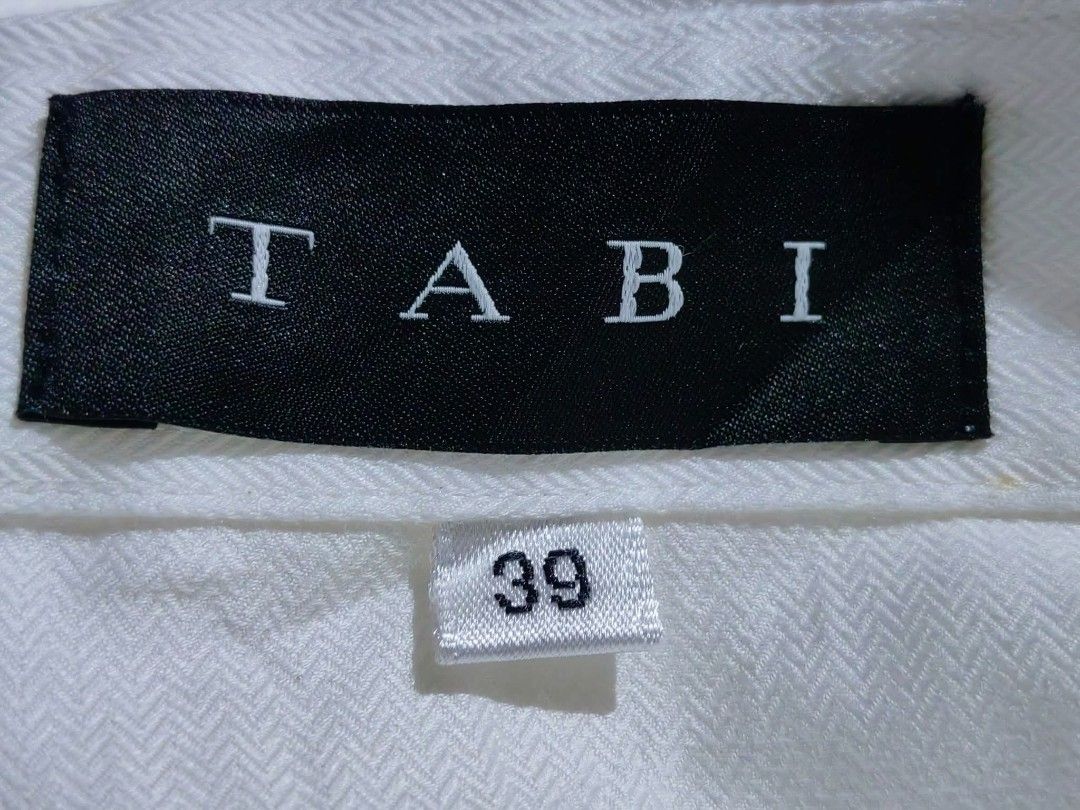TABI herringbone weave White Short Sleeve Button Up Shirt (Category: Shirts) located in Donsol. Submitted by saksthriftavenuebyluckymaria8 (Listing ID 1459867405, Image 3). Description: - Classic white short sleeve shirt - Brand: TABI - Features: Button-up front, collar - Style: Simple, clean, sharp, neat - Versatile: Great for work or casual wear, easy to pair with anything TABI HERRINGBONE WEAVE PATTERN WHITE sz 39 fits M chest 20in length 24in