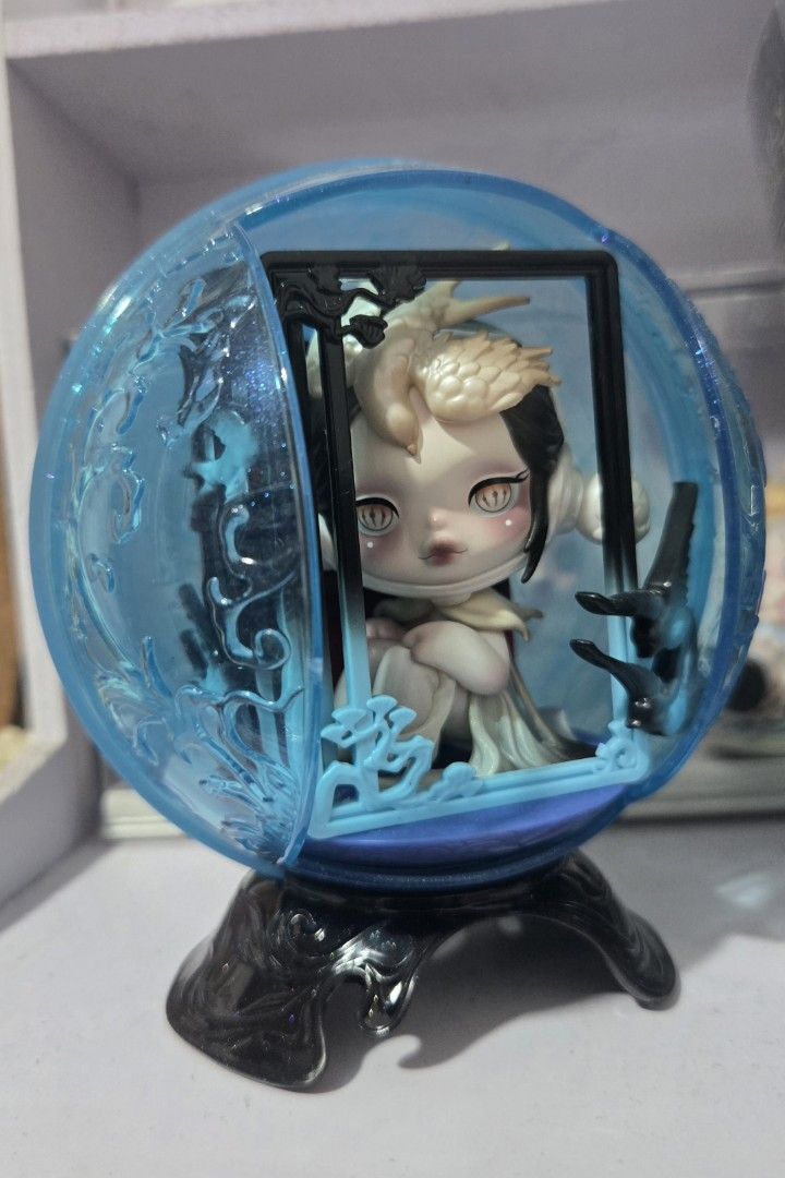 "The Frame" SKULLPANDA The Mirage Series (Category: Designer & Blind Box Toys) located in Manila. Submitted by fierceriver.e57033 (Listing ID 1459793551, Image 1). Description: - Adorable collectible figure - Encased in a blue crystal ball - Figure has big eyes and unique hairstyle - Sitting pose with red cloth accent - Crystal ball features intricate external designs - Includes a sturdy black stand - Ideal display piece for collectors.
