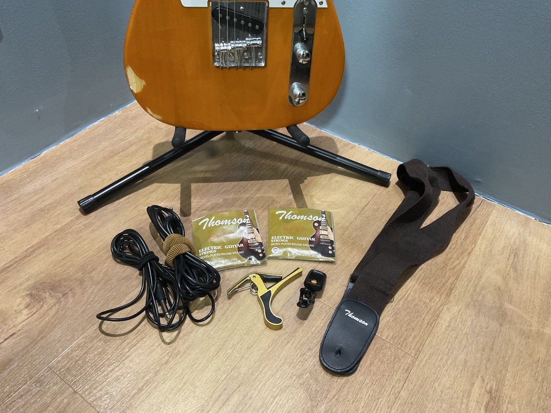 Thompson Telecaster Butterscotch ELECTRIC GUITAR with strings (Category: Musical Instruments) located in Manila. Submitted by zftkkyj5vn02573 (Listing ID 1459740040, Image 2). Description: PERSONAL OWNED colorway: butterscotch orange / white🔥 freebies: with thompson accesories 2 extra strings capo issues: shown at picture bottom left part of the guitar 📍ANTIPOLO via LALAMOVE.