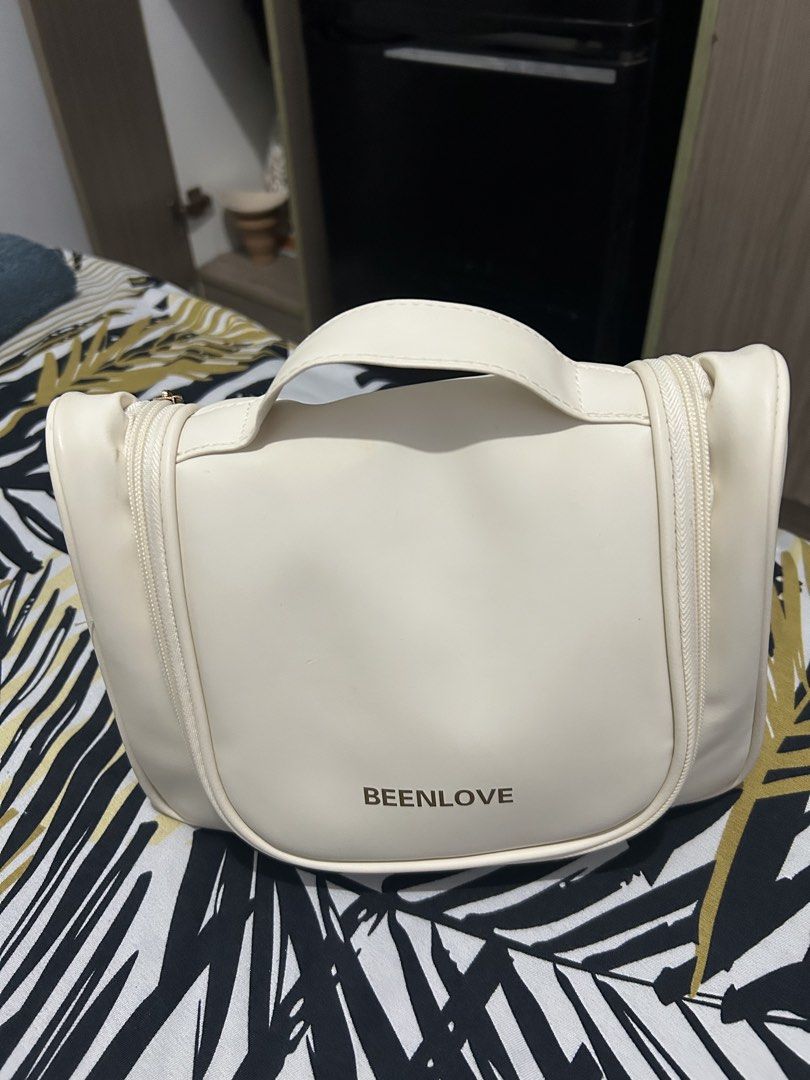 Toiletries bag (Category: Purses & Pouches) located in Quezon City. Submitted by chastnavarrete (Listing ID 1459880654, Image 1). Description: - Cream-colored cosmetic bag - Features a convenient handle - Dual zippers for easy access - Interior compartments for toiletries and makeup.