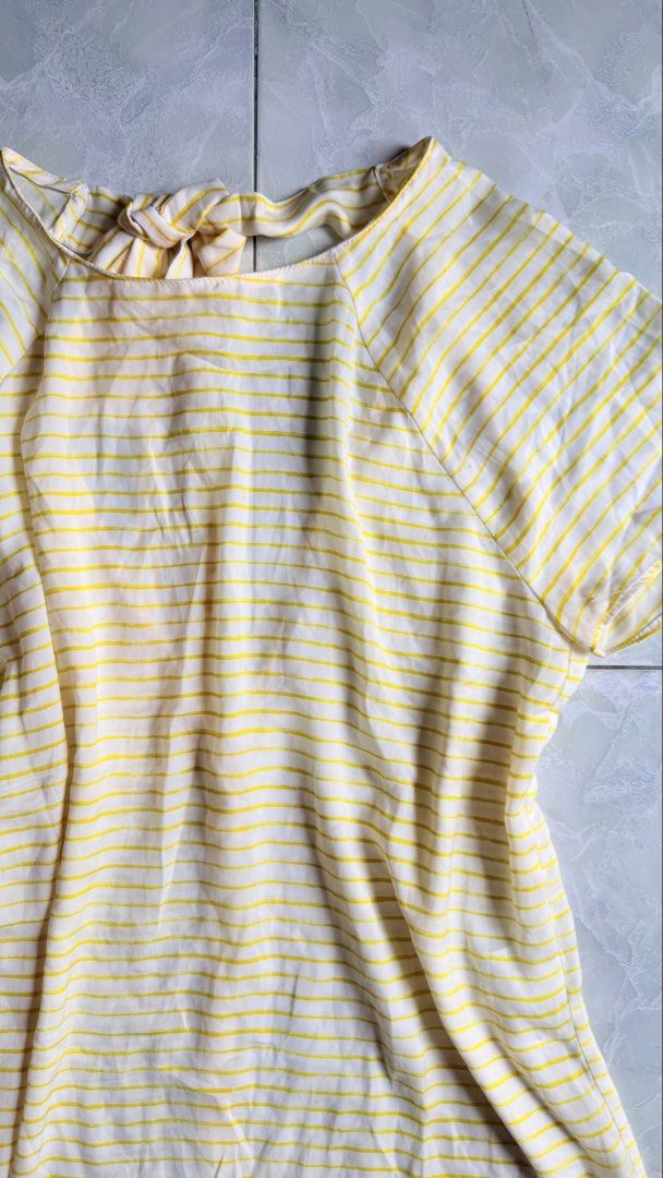 TRAFALUC Yellow Striped Tie Back Top (Category: Blouses) located in General Santos City (Dadiangas). Submitted by ssssshhhhhhhhh (Listing ID 1459743978, Image 2). Description: - Cute yellow and white striped top from TRAFALUC. - Short sleeves with a tie detail at the back. - Functional buttons down the front. - Minor mark on the sleeve (refer to the last photo). - Ideal for casual everyday wear..