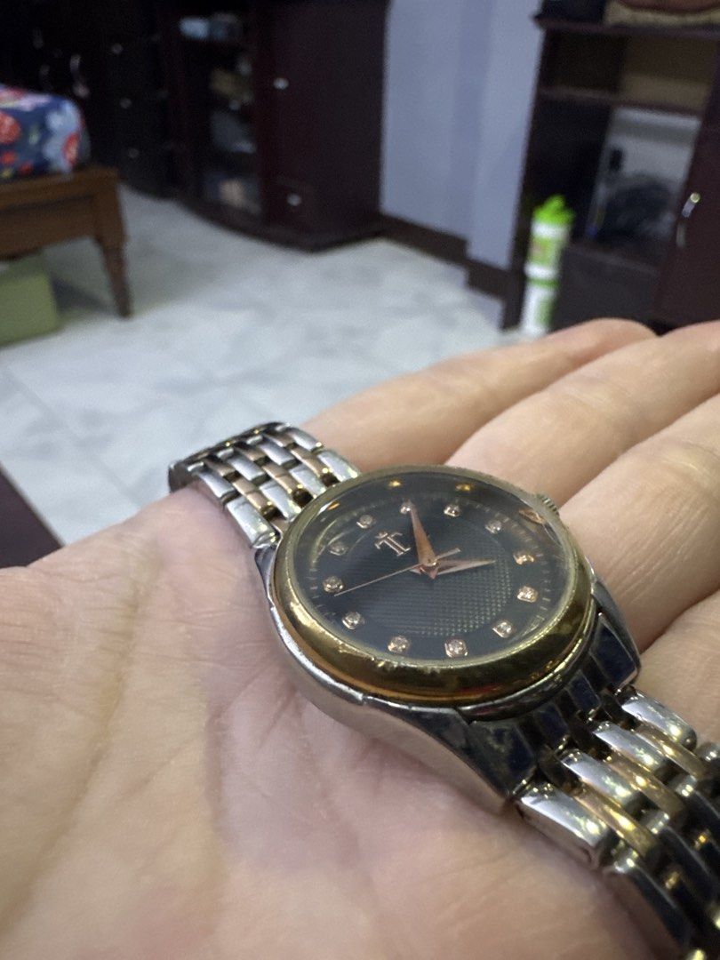 Two-tone Watch with Diamond Markers (Category: Women's Watches) located in Valenzuela. Submitted by arizanatividad (Listing ID 1459805944, Image 2). Description: - Classic round watch face - Black dial with sparkling diamond markers - Elegant silver and rose gold tone band - Convenient right-side crown - A perfect accessory to elevate any outfit.