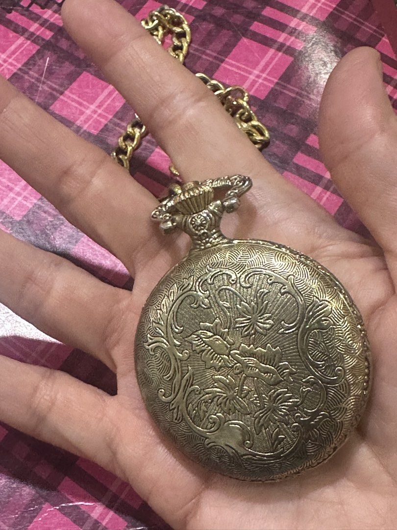 Vintage Gold Eagle Pocket Watch with Chain (Category: Women's Watches) located in Manila. Submitted by roseluxuryitems (Listing ID 1459718654, Image 3). Description: - Gold-tone pocket watch - Features an eagle design on the front cover - Intricate scrollwork on the back - White watch face with black numbers and hands - Quartz movement - Comes with a matching gold chain - Ideal for collectors or as a unique accessory.