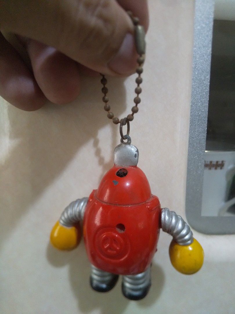 Vintage Red Robot Keychain Lighter with Ball Chain (Category: Vintage Collectibles) located in Binan City. Submitted by rpute (Listing ID 1459703845, Image 2). Description: - Adorable red robot design - Features yellow hands and black feet - Silver, accordion-style arms - Ball chain shows some wear - Ideal for decorating bags or keys - A fun, retro collectible item.