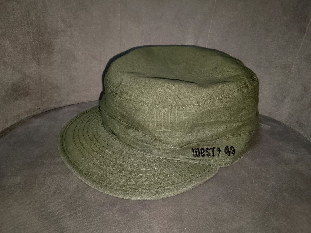 West 49 Cadet/Patrol Cap Size Small (Category: Caps & Hats) located in Binangonan. Submitted by yuristalin888 (Listing ID 1459809381, Image 2). Description: This olive green cadet/military-style cap features a durable grid-pattern ripstop fabric, a flat top crown, and a curved brim with stitched detailing. It is accented with bold black embroidery on the side reading "WEST 49"..