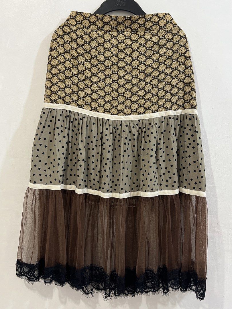 Rare Whimsical / Cottage core skirt (Category: Skirts) located in Cavite. Submitted by wishie_collects (Listing ID 1459803889, Image 3). Description: Design: A whimsical, multi-tiered midi skirt featuring three distinct patterned sections divided by white piping lines. Details: It starts with a brown and beige floral print yoke, flows into an olive green polka-dot ruffled tier, and finishes with a sheer brown tulle layer trimmed with delicate bla