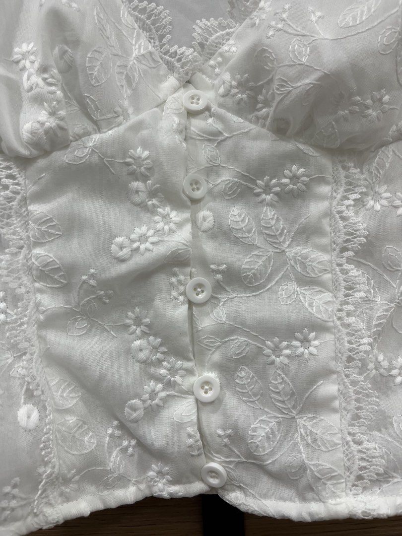 White Embroidered Button-Up Crop Top XS (Category: Blouses) located in Mabalacat. Submitted by fashionclothesph (Listing ID 1459822655, Image 2). Description: - Cute white crop top - Floral embroidery detail - V-neckline - Button-up front - Short sleeves with ruffled cuffs - Versatile for pairing with jeans or skirts - Ideal for casual outings or summer picnics.