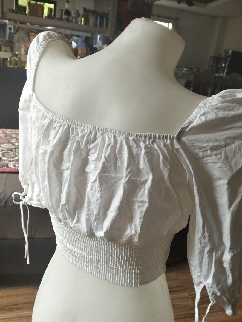 White Smocked Square Neck Crop Top (Category: Sleeveless) located in Bulacan. Submitted by kikay2000 (Listing ID 1459783861, Image 3). Description: - White crop top - Smocked waist for a flattering fit - Square neckline with adjustable tie detail - Chic puff sleeves ending at the elbow - Ties at the sleeve ends for a customizable look - Effortlessly pairs with high-waisted bottoms.