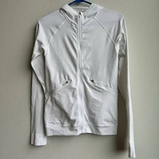 Lululemon White Zip-Up Hoodie with Pockets (Category: Activewear) located in Paranaque City. Submitted by __thegoodfinds (Listing ID 1459800308, Image 1). Description: - White zip-up hoodie with hood - Two zippered front pockets - Lightweight material - Textured panels on chest and sleeves - Ideal for workouts or casual wear - Easy to layer.