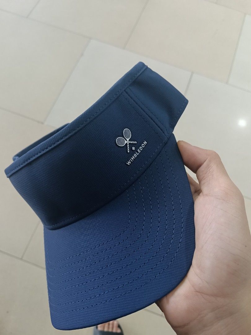 Wimbledon Navy Blue Tennis Visor Cap (Category: Caps & Hats) located in Manila. Submitted by shayydee (Listing ID 1459728940, Image 2). Description: - Official Wimbledon navy blue visor. - Iconic embroidered tennis racket logo on the front. - Adjustable strap at the back for a custom fit. - Ideal for sunny days, tennis, or casual wear. - Inner tag shows 'Wimbledon Est. 1877'..