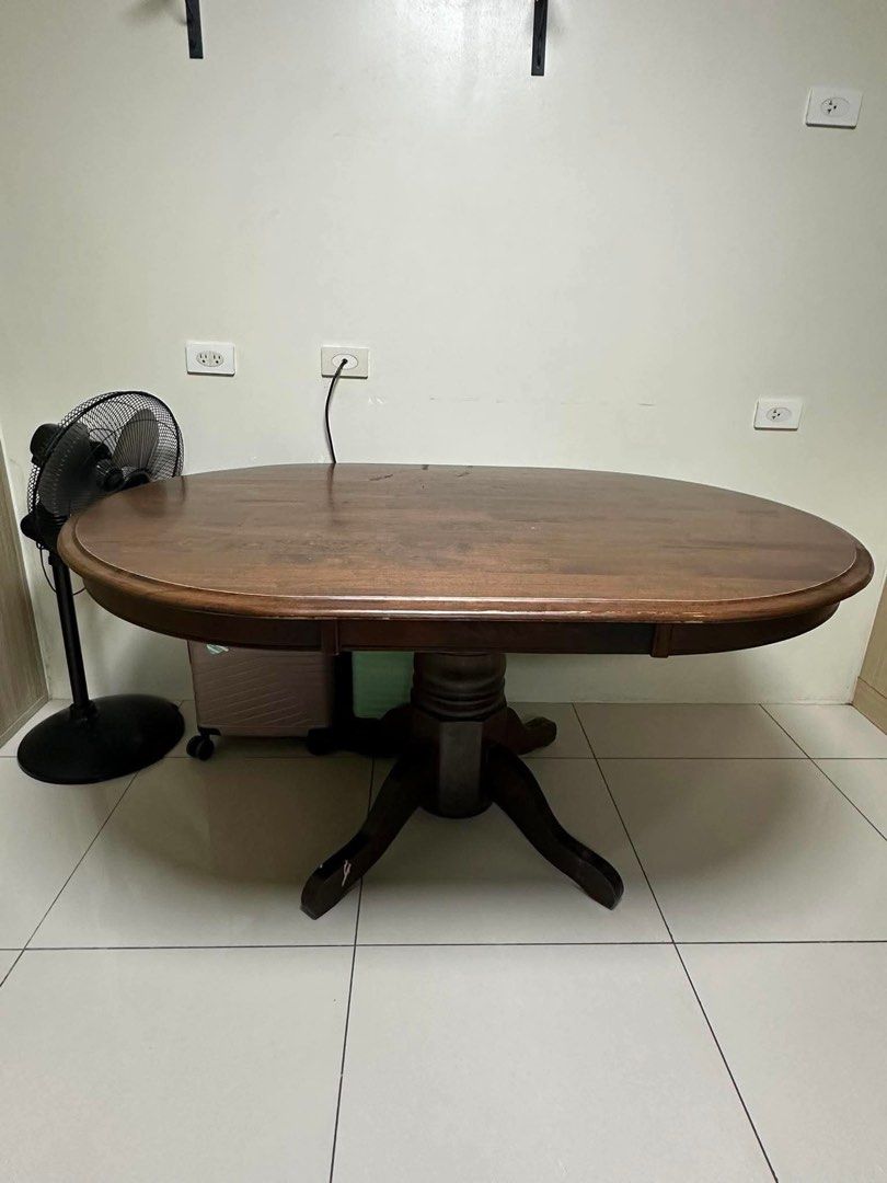 Wooden Oval Dining Table (Category: Tables & Sets) located in Quezon City. Submitted by cheetowsz (Listing ID 1459837949, Image 1). Description: - Solid wood oval dining table - Rich, dark brown finish - Sturdy pedestal base - Minor scuffs on legs and surface (normal wear) - Ideal for family meals and entertaining guests.