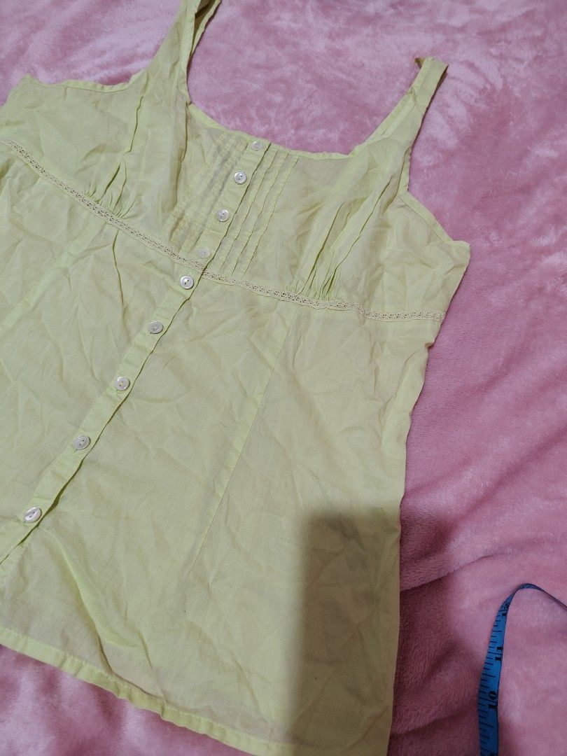 y2k Eddie Bauer Yellow Button-Up Tank Top (Category: Sleeveless) located in Villasis. Submitted by trip_thrift15 (Listing ID 1459726387, Image 3). Description: - Yellow tank top from Eddie Bauer - Square neckline with button-up front - Pintuck details on the bodice - Lace trim above bust and at hem - Thin straps - Made of 100% cotton need wash sleeve part MOP-GCASH JNT COURIER PRICE+SF.