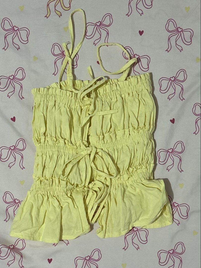 Yellow Smocked Tie Front Crop Top (Category: Sleeveless) located in Daet. Submitted by 614cb (Listing ID 1459718569, Image 1). Description: - Adorable yellow smocked crop top - Features a cute tie-front detail - Adjustable straps for a perfect fit - Playful ruffled hemline - Made from lightweight and breezy fabric - Ideal for casual outings or beach days - Effortlessly pairs with shorts or skirts Never been used, i have another one in black still