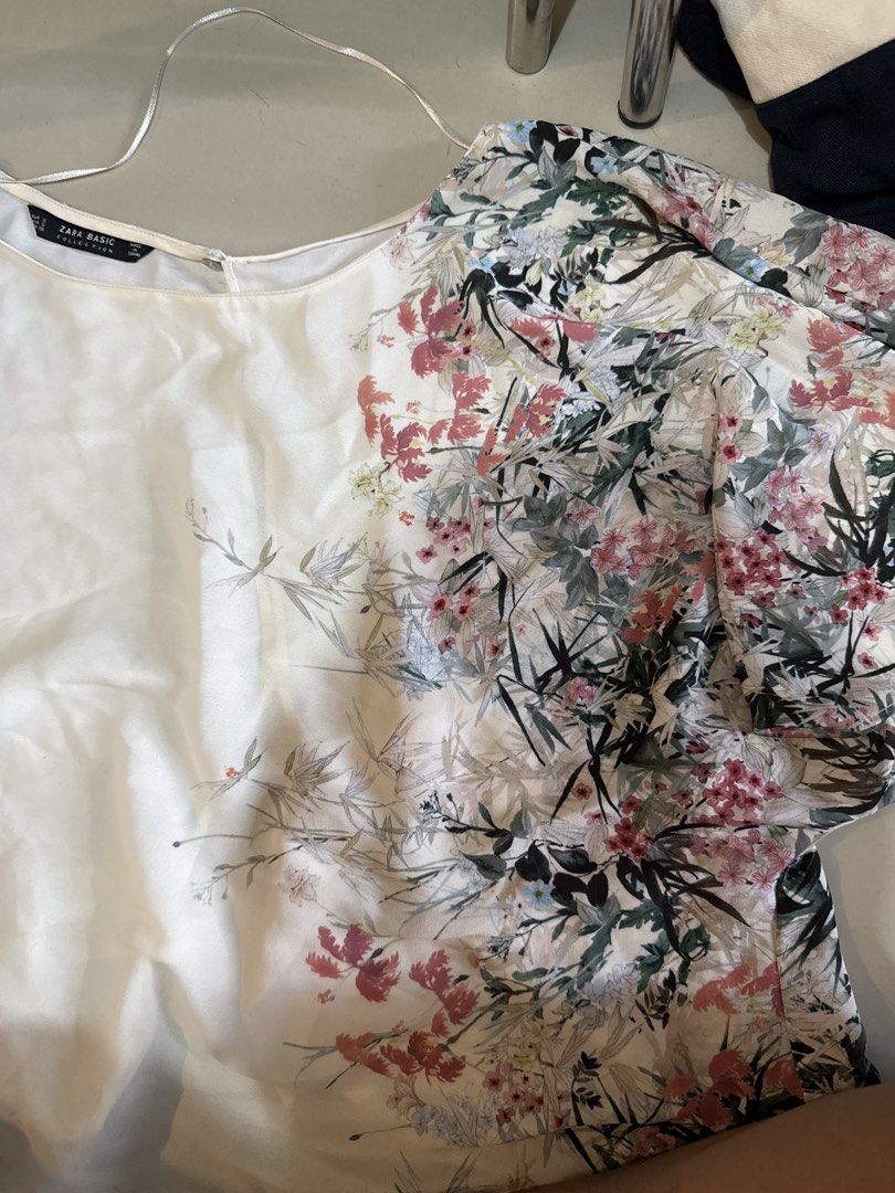 Zara Collection Floral Print Top (Category: Blouses) located in Manila. Submitted by hiiipurple (Listing ID 1459765611, Image 1). Description: - White top with beautiful floral print on sleeves and front - Plain white back - Tie detail at the bottom - Lightweight material, ideal for warm weather - Versatile: easily styled with jeans or skirts.