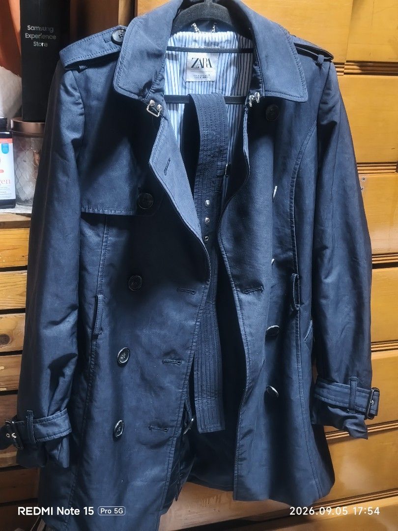 ZARA Double Breasted Navy Trench Coat (Category: Coats, Jackets and Outerwear) located in Cainta. Submitted by condoandstuff (Listing ID 1459793040, Image 2). Description: - Navy blue trench coat from ZARA - Double-breasted with button closure - Belted waist and adjustable cuffs - Classic trench details: epaulets and storm flap - Fully lined interior - Ideal for layering.