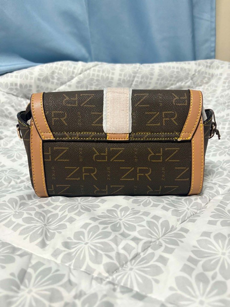 ZR Monogram Trunk Bag (Category: Luxury Bags & Wallets) located in Manila. Submitted by vengonflo (Listing ID 1459793248, Image 2). Description: - Stylish brown ZR monogram trunk bag - Elegant tan trim and gold hardware - Secure clasp closure - Adjustable strap for comfort - Compact, mini trunk design - Ideal for carrying daily essentials.
