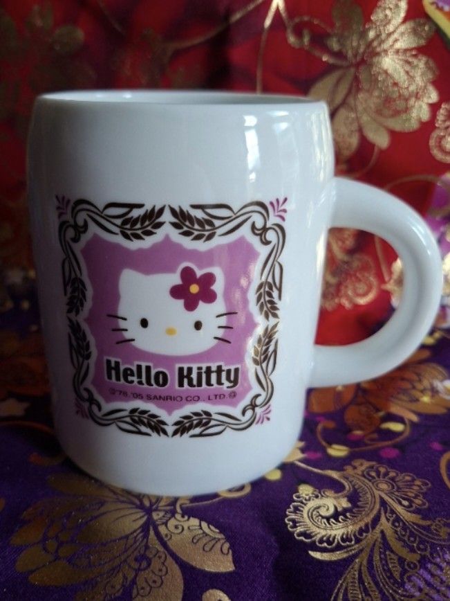 2005 Sanrio Hello Kitty Mug (Category: Coffee & Tea Tableware) located in Consolacion. Submitted by luxekerei (Listing ID 1456946159, Image 1). Description: - vintage 2005 Sanrio Hello Kitty ceramic mug featuring an ornate purple and pink flower frame design..