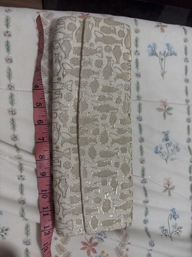 2027 Gold and White Patterned Clutch Bag (Category: Clutches) located in Silang. Submitted by sari2bilina (Listing ID 1459922563, Image 2). Description: - Chic gold and white patterned clutch - Secure snap closure - Soft peachy-pink fabric lining inside - Dimensions: Approx. 10 inches long, 3 inches wide - Ideal for evening wear and special occasions.