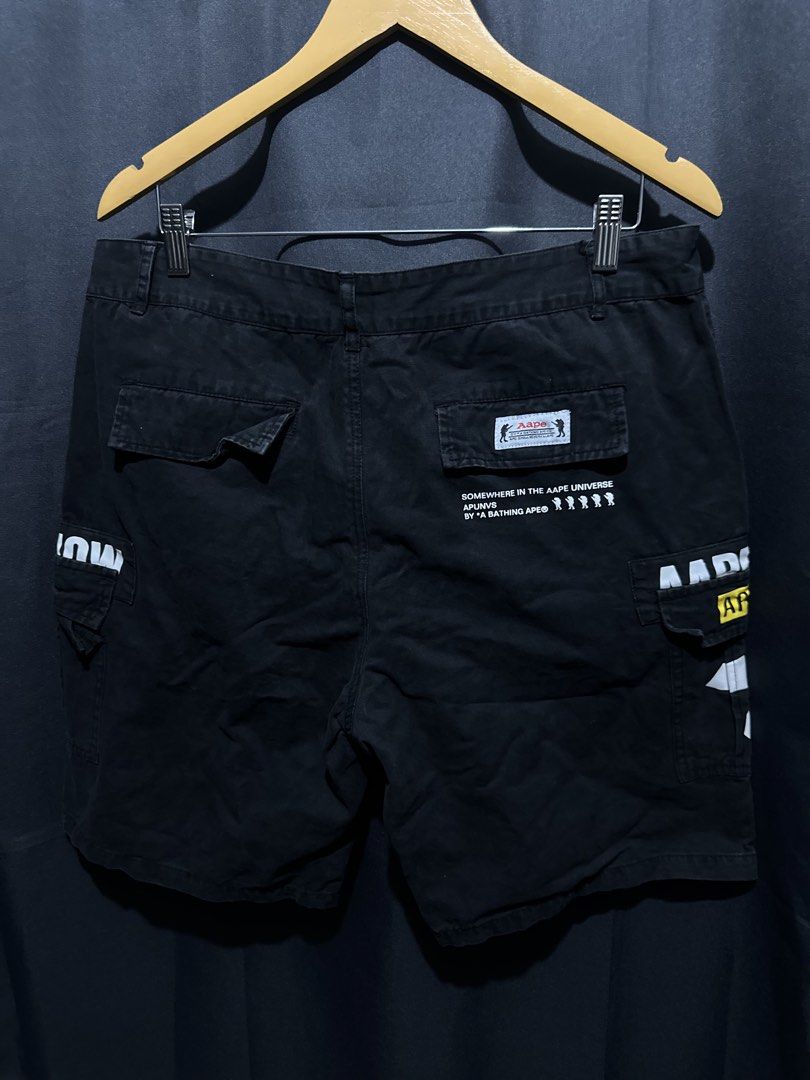 AAPE BY A BATHING APE Cargo Shorts (Category: Shorts) located in Buenavista. Submitted by themodernrack (Listing ID 1460042888, Image 2). Description: Brand: AAPE BY *A BATHING APE Color: Black Style: Graphic Cargo Shorts (Features signature AAPE graphic prints, AAPE UNVS patches, rubberized Moon Face emblem on front hip, branded waist button, rear flap pocket with brand tag, and back text graphic print) Tag Size: Unspecified / Standard Fit Condi