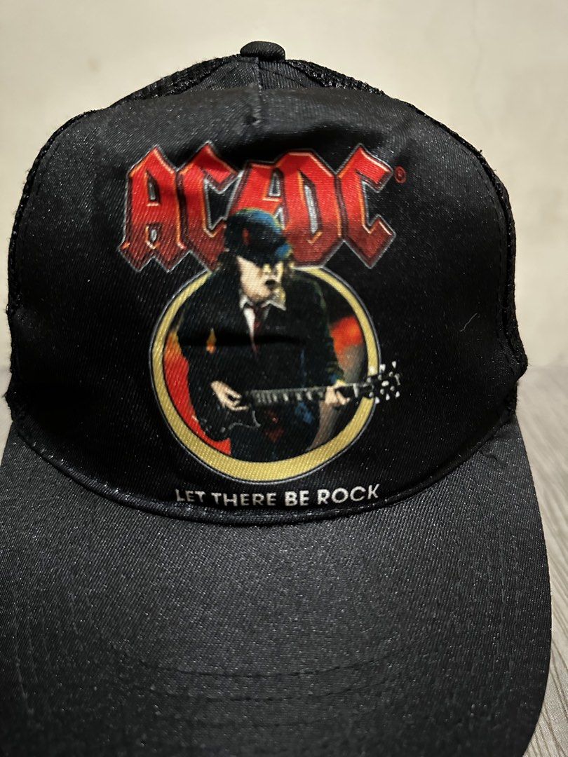ACDC Let There Be Rock Trucker Cap (Category: Caps & Hats) located in Bacoor. Submitted by realbacktrack (Listing ID 1459905641, Image 2). Description: - Black trucker cap with ACDC 'Let There Be Rock' graphic - Features the iconic band logo and Angus Young playing guitar - Breathable mesh back for comfort - Adjustable snapback closure for a perfect fit - Size M - A must-have for any AC/DC enthusiast! *needs reshape *loose stitch on strap (see pi