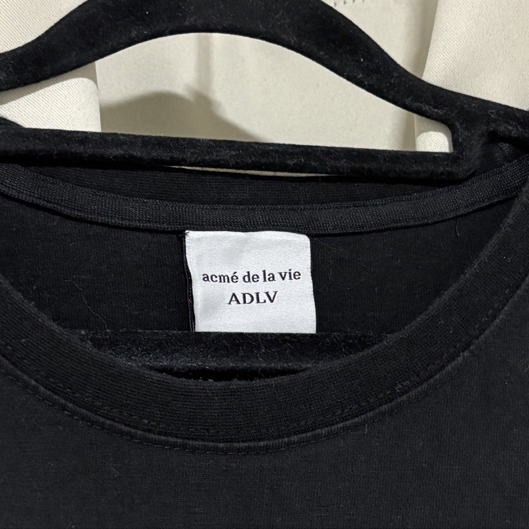 ACMÉ DE LA VIE (Category: Tshirts & Polo Shirts ) located in Quezon City. Submitted by grailph (Listing ID 1460035041, Image 2). Description: - Brand: ACMÉ DE LA VIE (ADLV) - Color: Black - Color rate 9/10 - Size 1 On tag - Dimensions 22”x29” boxy fit - Material: 100% Cotton - Design: Features a unique graphic print of a child with a cookie - Condition: Good, pre-loved - Available for meet-up in Commonwealth North Fairview NO CRACKPRINTS -Minor r