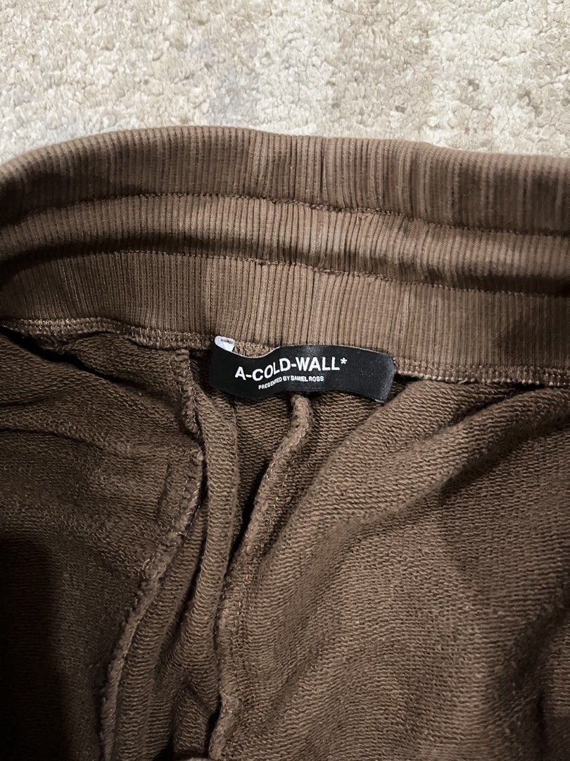 A-COLD-WALL* Brown Bleached Logo Sweatpants Size XL (Category: Joggers) located in Caloocan City. Submitted by jp.racan01 (Listing ID 1460007845, Image 2). Description: - Brand: A-COLD-WALL* - Color: Brown - Design: All-over bleached effect - Logo: ACW logo on leg - Origin: Made in Portugal - Features: Elastic waistband with drawstring, ribbed cuffs - Style: Ideal for casual wear Condition 9/10 Size XL 32 - 40 Length 104cm No issue.