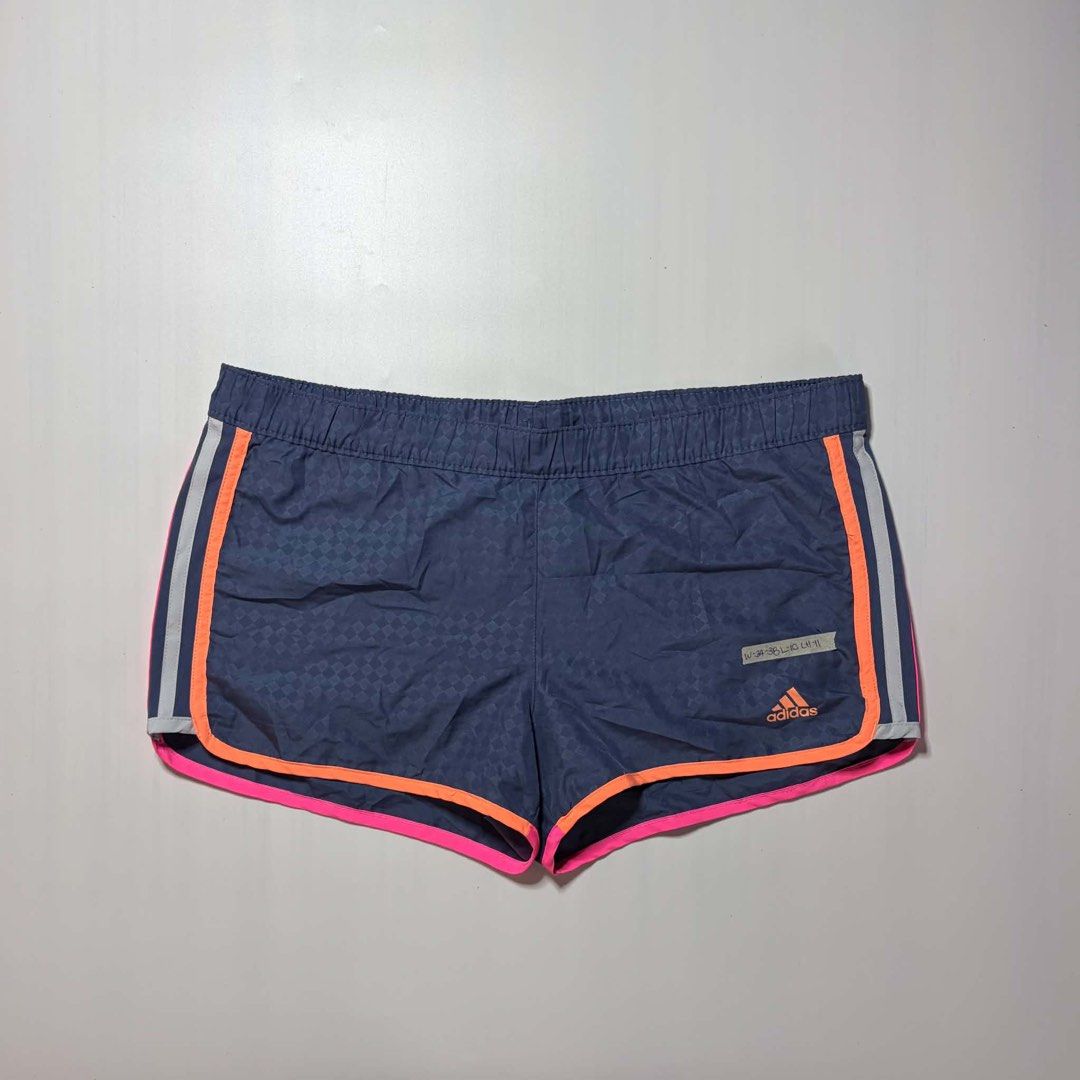 Adidas ClimaLite Athletic Shorts Size M (Category: Shorts) located in Baguio. Submitted by cosmogyralfinds (Listing ID 1460057503, Image 3). Description: - Navy blue Adidas shorts - Checkered pattern with bright pink and orange trim - ClimaLite fabric for excellent breathability - Elastic waistband with drawstring for a secure fit - Ideal for running, workouts, or casual wear - Size: Medium (fits waist 34-38 inches).