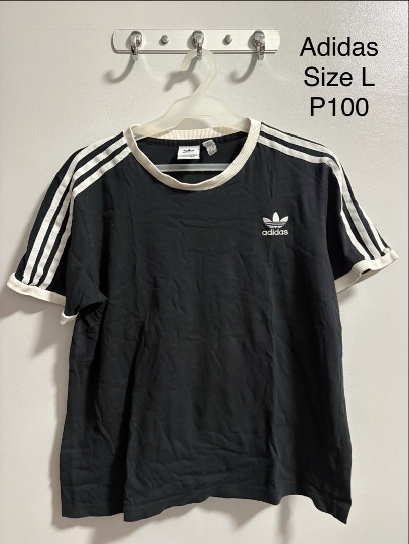 Adidas T-shirt (Category: Tshirts & Polo Shirts ) located in Marikina City. Submitted by snowinsummerph (Listing ID 1460019446, Image 1). Description: - Classic black Adidas t-shirt - White stripes on sleeves - Iconic Adidas logo on chest - Size: Large (L) - Comfortable and stylish for everyday casual outfits.