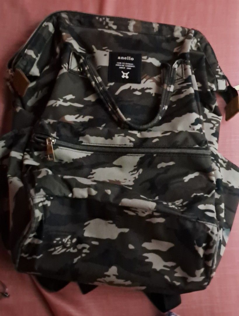 Anello Camouflage Backpack (Category: Backpacks) located in Manila. Submitted by blitzenn.blitzenn (Listing ID 1460036350, Image 1). Description: - Stylish Anello backpack with a cool camouflage print. - Ample interior space with multiple pockets for organization. - Zippers are in excellent working condition. - Adjustable straps for a comfortable fit. - Ideal for everyday use, school, or travel. - Convenient side pockets for quick access items..