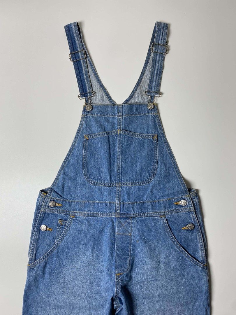 APC DENIM OVERALL (Category: Jumpsuits) located in Balanga. Submitted by dig_gear (Listing ID 1459940010, Image 2). Description: APC DENIM OVERALL This mid-weight A.P.C. denim overall features a classic medium-blue wash with a relaxed, straight-leg silhouette. It includes standard adjustable suspender straps, a signature curved stitch bib pocket, classic five-pocket styling, and branded silver-tone button closures along the waist. MADE IN TUNISIA