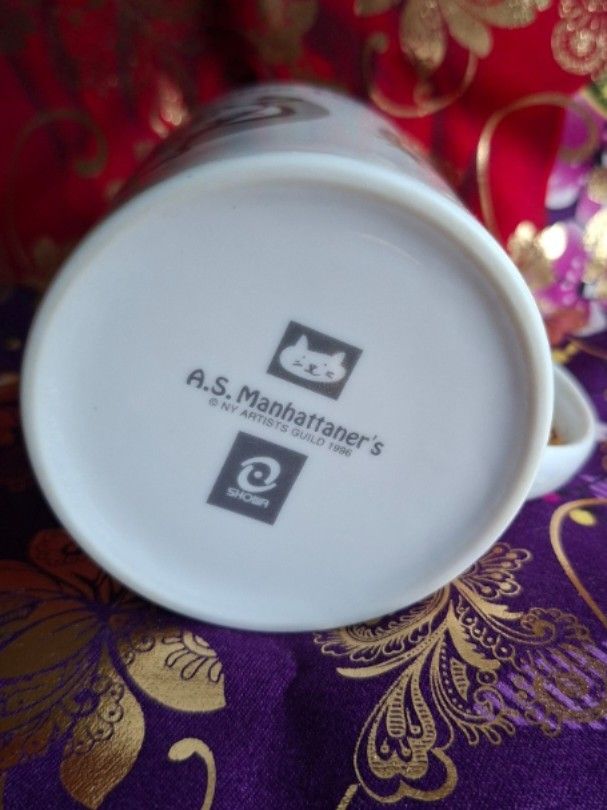 A.S. Manhattaner's Cat Mug (Category: Coffee & Tea Tableware) located in Consolacion. Submitted by luxekerei (Listing ID 1456912063, Image 3). Description: - A.S. Manhattaner's ceramic cat mug featuring a playful feline face logo on the bottom hallmark..