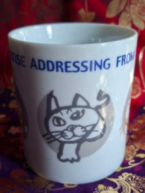 A.S. Manhattaner's Cat Mug (Category: Coffee & Tea Tableware) located in Consolacion. Submitted by luxekerei (Listing ID 1456912063, Image 1). Description: - A.S. Manhattaner's ceramic cat mug featuring a playful feline face logo on the bottom hallmark..