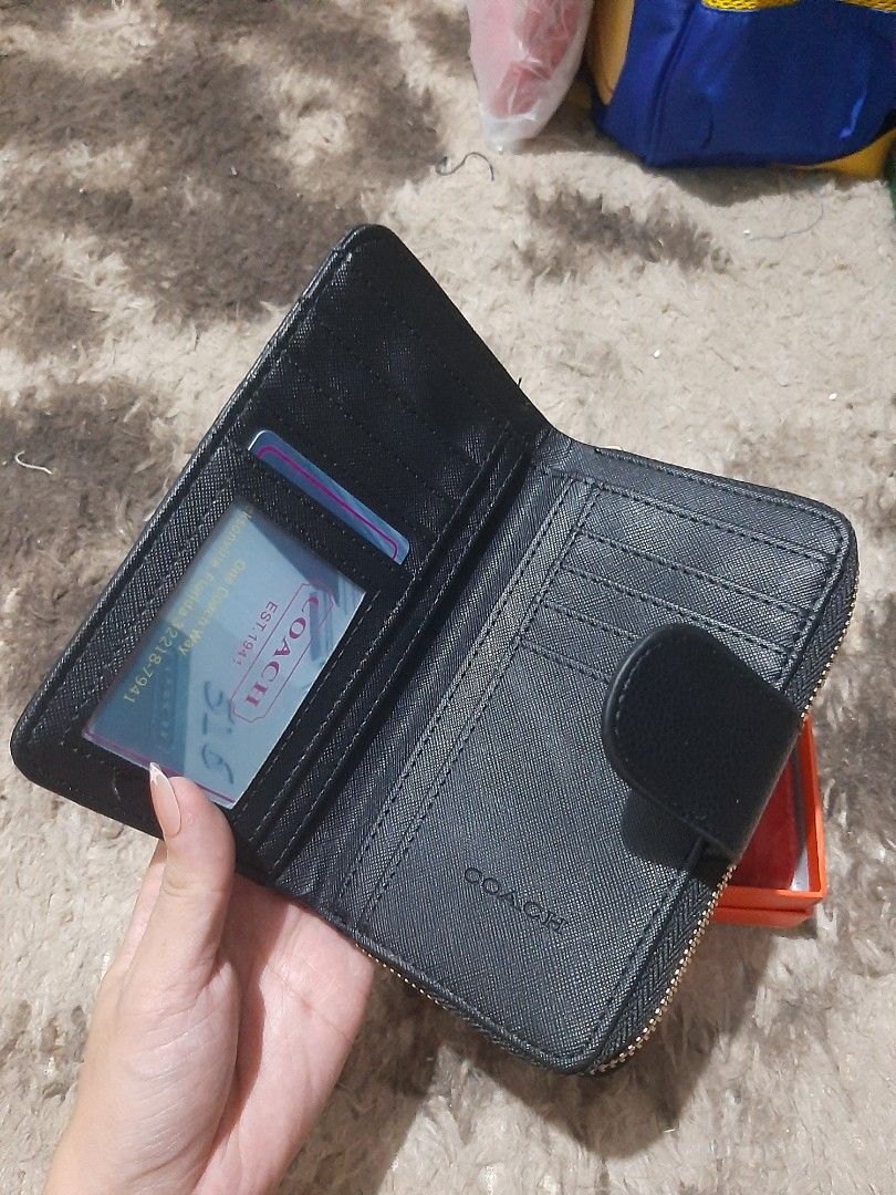 Bi-fold Wallet with zip pocket (Category: Wallets & Card holders) located in Davao. Submitted by nisa_chan04 (Listing ID 1460077878, Image 3). Description: - Medium size wallet in classic black/red with embossed signature C pattern, non embossed design in two-toned color. - Secure zip-around closure and a convenient snap button flap. - Interior features multiple card slots and a clear ID window. - Includes a zippered compartment for coins or smal