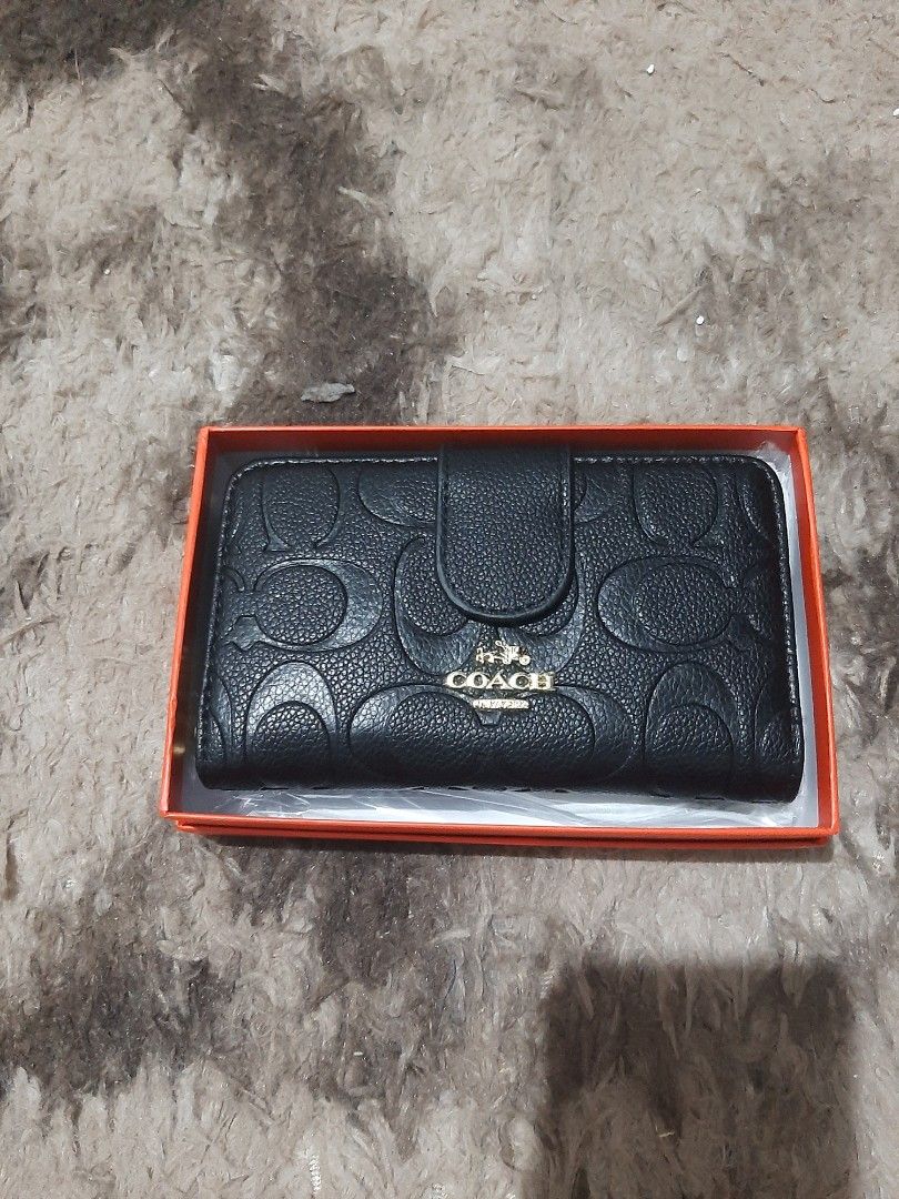 Bi-fold Wallet with zip pocket (Category: Wallets & Card holders) located in Davao. Submitted by nisa_chan04 (Listing ID 1460077878, Image 2). Description: - Medium size wallet in classic black/red with embossed signature C pattern, non embossed design in two-toned color. - Secure zip-around closure and a convenient snap button flap. - Interior features multiple card slots and a clear ID window. - Includes a zippered compartment for coins or smal